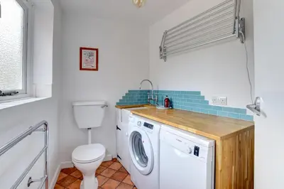 a bathroom with a washing machine and a toilet at 2 Bed in Orford oc-sflpo in Orford