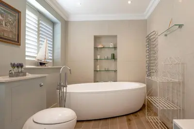 a bathroom with a tub and a toilet and a sink at 5 Bed in Orford oc-pav in Orford