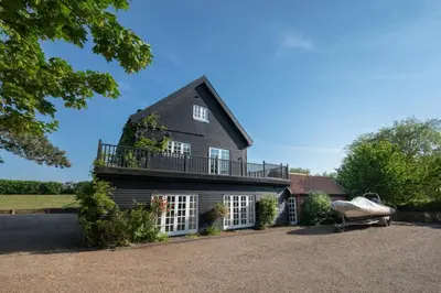 a house with a balcony on top of it at 5 Bed in Orford oc-pav in Orford