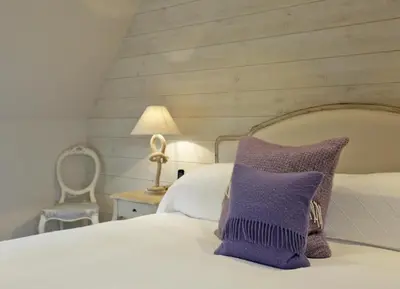 a white bed with a purple pillow on it at 2 Bed in Thorpeness oc-vels in Thorpeness