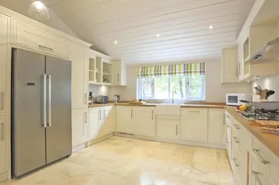 a kitchen with white cabinets and a stainless steel refrigerator at 2 Bed in Thorpeness oc-vels in Thorpeness