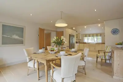 a dining room with a wooden table and white chairs at 2 Bed in Thorpeness oc-vels in Thorpeness