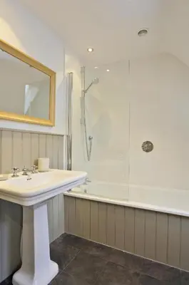 a white bathroom with a sink and a shower at 2 Bed in Thorpeness oc-vels in Thorpeness
