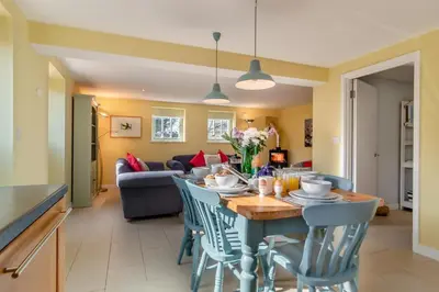 a dining room and living room with a table and chairs at 3 Bed in Knodishall oc-wbco in Aldringham