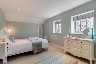 a bedroom with a bed and a desk with a laptop at 3 Bed in Knodishall oc-wbco in Aldringham