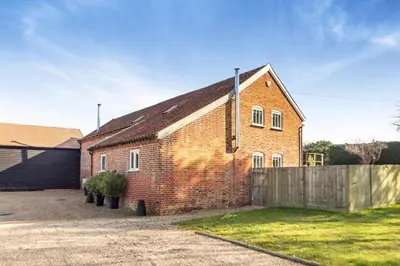 an old brick building with a wooden fence at 3 Bed in Knodishall oc-wbco in Aldringham