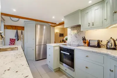 a kitchen with white cabinets and a stainless steel refrigerator at 3 Bed in Woodbridge oc-h23 in Woodbridge