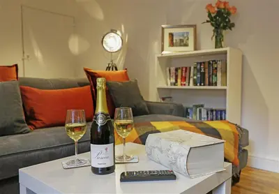 a bottle of wine and two glasses on a table at 2 Bed in Aldeburgh oc-tsc in Aldeburgh