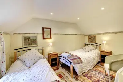 a bedroom with two beds and a chair at 3 Bed in Nr Aldeburgh oc-sfwws in Snape