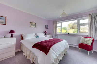 a bedroom with a large white bed and a window at 4 Bed in Halesworth oc-willho in Halesworth