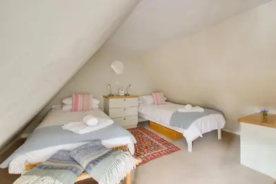 a attic bedroom with two beds and a dresser at 2 Bed in Woodbridge oc-csn2 in Woodbridge