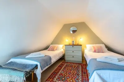 a attic bedroom with two twin beds and a dresser at 2 Bed in Woodbridge oc-csn2 in Woodbridge