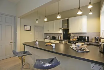 a large kitchen with a counter and chairs in it at 2 Bed in Orford oc-sfwco in Orford