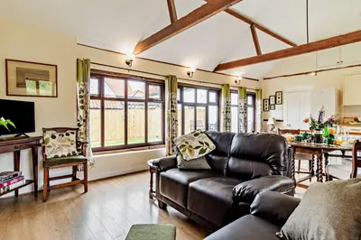 a living room with a leather couch and a table at 1 Bed in St. James South Elmham Halesworth oc-t27361 in Saint James