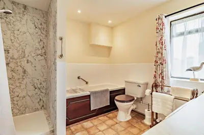 a bathroom with a tub and a toilet and a shower at 1 Bed in St. James South Elmham Halesworth oc-t27361 in Saint James