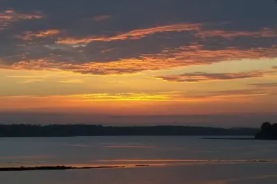 a sunset over a large body of water at River Cottage - Stunning estuary views in Aldeburgh