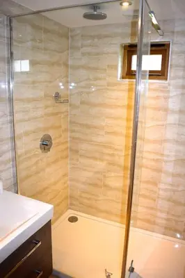 a shower with a glass door in a bathroom at River Cottage - Stunning estuary views in Aldeburgh