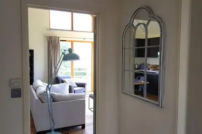 a living room with a chair and a mirror at River Cottage - Stunning estuary views in Aldeburgh