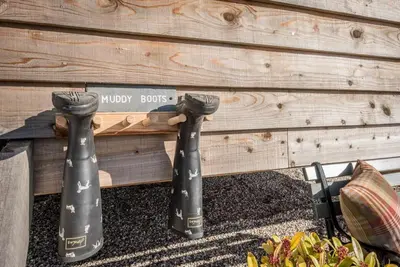 three black ties sitting next to a wooden wall at Lily Pad, Friston in Saxmundham