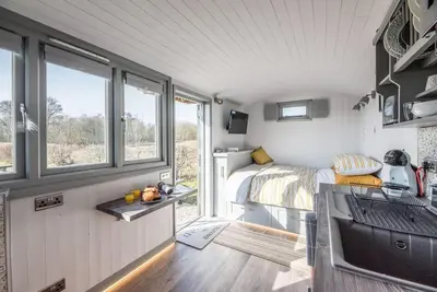 a tiny house with a bedroom and a bed at Lily Pad, Friston in Saxmundham