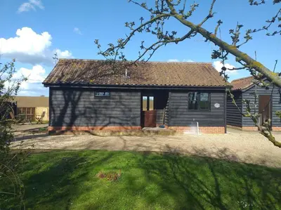 a small house with a grass yard in front of it at ROSE CHALET in Framlingham