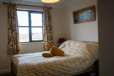 a bedroom with a bed with a yellow pillow on it at ROSE CHALET in Framlingham