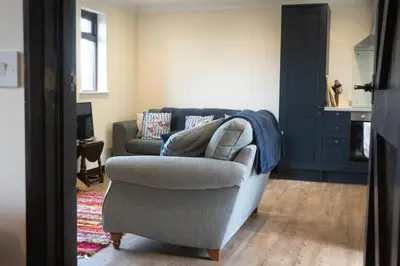 a living room with a couch and a chair at ROSE CHALET in Framlingham