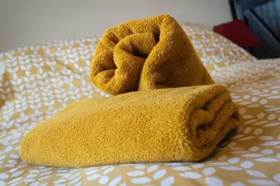 a pair of towels sitting on top of a bed at ROSE CHALET in Framlingham