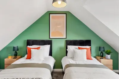 two beds in a room with a green wall at Grab a Deal Today! Massive Home For Contractors & Parking for 4 in Chelmsford