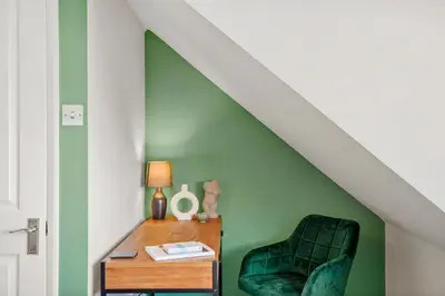 a green room with a chair and a table at Grab a Deal Today! Massive Home For Contractors & Parking for 4 in Chelmsford