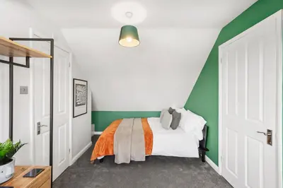 a bedroom with green and white walls and a bed at Grab a Deal Today! Massive Home For Contractors & Parking for 4 in Chelmsford