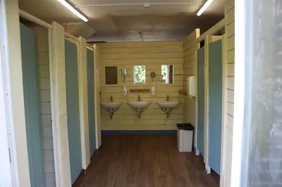 a bathroom with three sinks in the wall at The Woodpecker shepherd hut in Elmswell