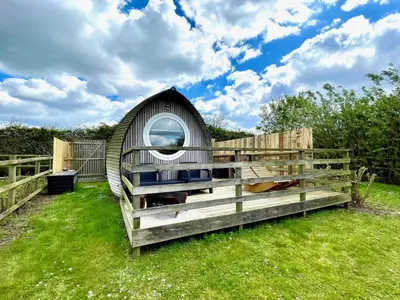 a small shed with a mirror on a fence at Armadilla 1 at Lee Wick Farm Cottages & Glamping in Clacton-on-Sea