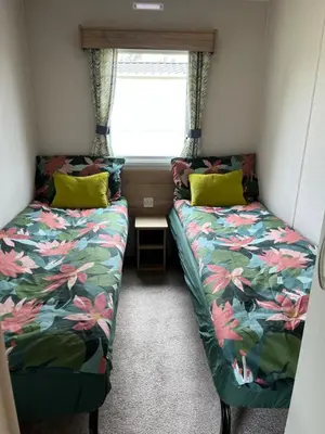 two beds in a small room with a window at Arizona - Pura Vida Holidays Caravan in Clacton-on-Sea