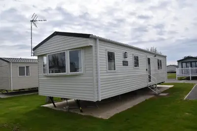 a white tiny house is parked in a yard at Arizona - Pura Vida Holidays Caravan in Clacton-on-Sea