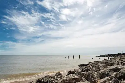 a beach with rocks and people in the water at Arizona - Pura Vida Holidays Caravan in Clacton-on-Sea