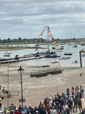 a crowd of people watching a group of boats in the water at Harbour Walk in Brightlingsea