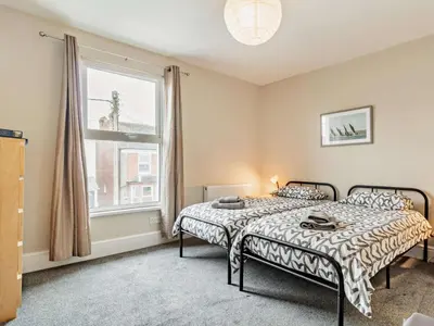 a bedroom with a bed and a large window at Harbour Walk in Brightlingsea