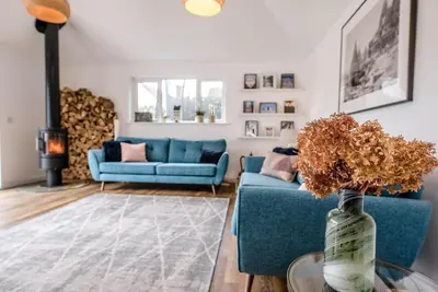 a living room with two blue couches and a fireplace at Springfield, Westleton in Westleton