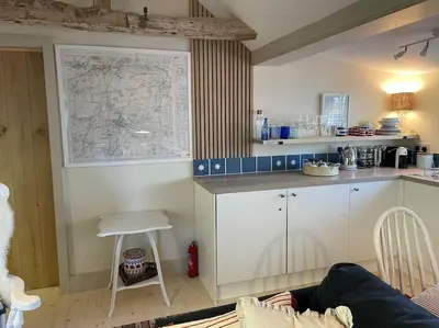 a room with a kitchen with a map on the wall at Mustard Pot Cottage in Eye