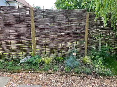 a wooden fence with plants in a garden at Mustard Pot Cottage in Eye