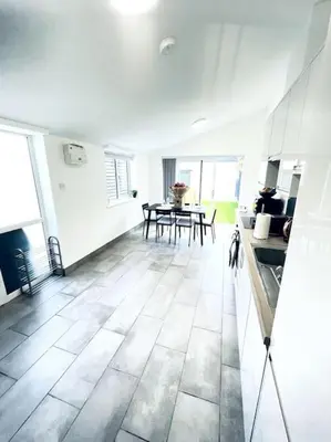 a large white room with a kitchen and a table at 2 Bedroom Modern House in Cambridge city centre in Chesterton
