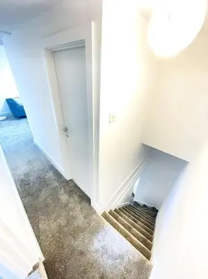 a hallway with a staircase leading to a closet at 2 Bedroom Modern House in Cambridge city centre in Chesterton