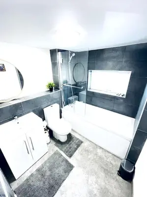 a bathroom with a tub and a toilet and a sink at 2 Bedroom Modern House in Cambridge city centre in Chesterton