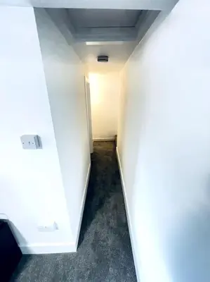 an empty hallway with a white wall and a door at 2 Bedroom Modern House in Cambridge city centre in Chesterton