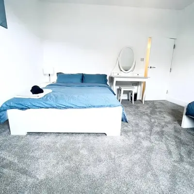 a bedroom with a large bed and a desk at 2 Bedroom Modern House in Cambridge city centre in Chesterton