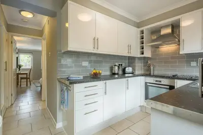 a kitchen with white cabinets and a counter top at Addenbrookes Flat 2 mins walk free Private Parking in Cambridge