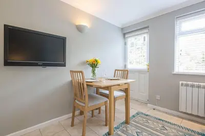 a dining room with a table and two chairs and a television at Addenbrookes Flat 2 mins walk free Private Parking in Cambridge