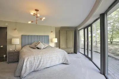 a bedroom with a bed and large windows at 6 Bed in Lavenham oc-stofa in Lavenham