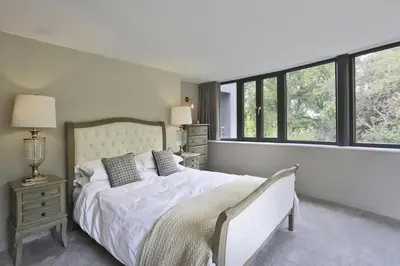 a bedroom with a large white bed with windows at 6 Bed in Lavenham oc-stofa in Lavenham